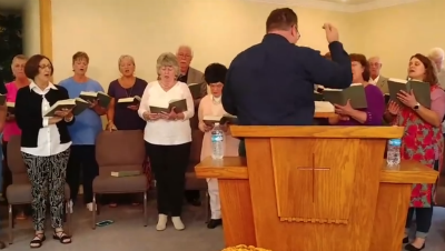Photo: Pastor Ben rehearsing with the choir.