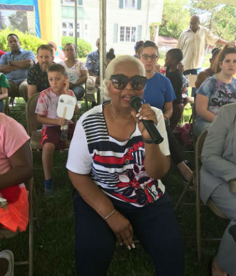 Photo: Pastor Sharon Montgomery testifies an an outdoor service.