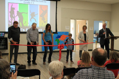 Photo: Pastor Kevin (far right) hosts the dedication of the new children and youth area.